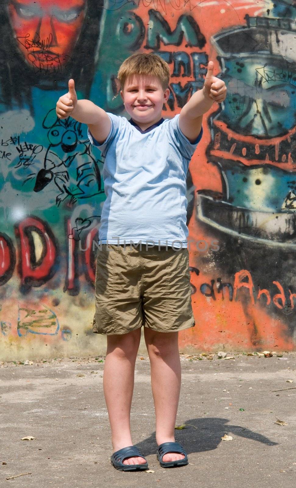 A smiling child with graffiti at background