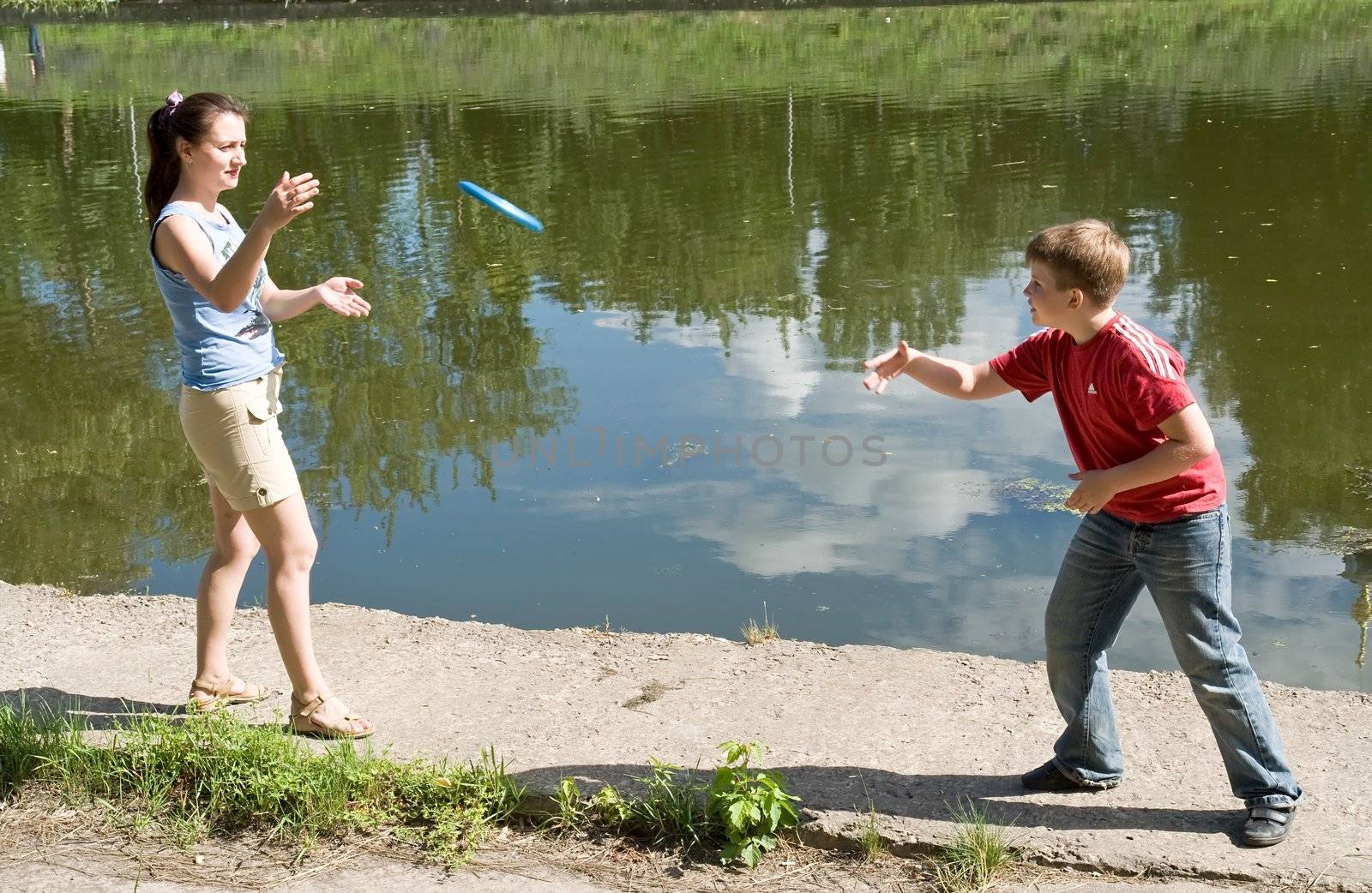 Mom and son playing frisbee with sky at background