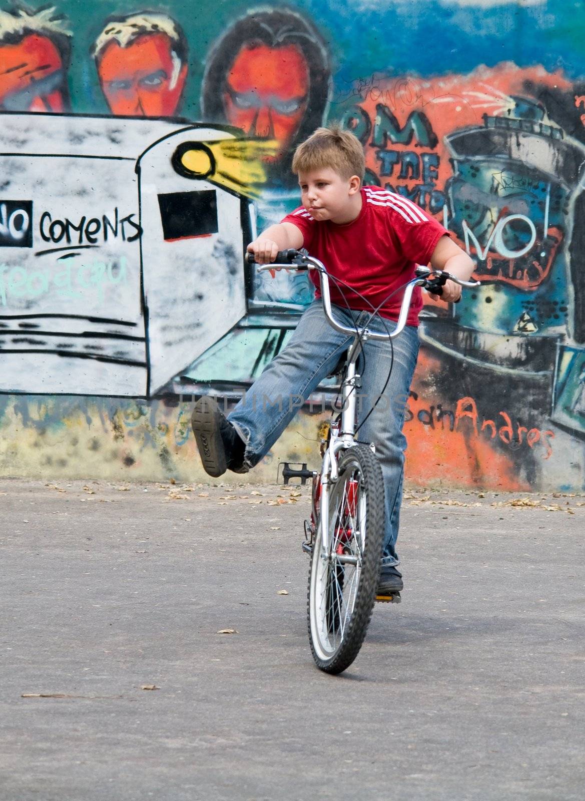 boy on a bicycle with graffiti at background
