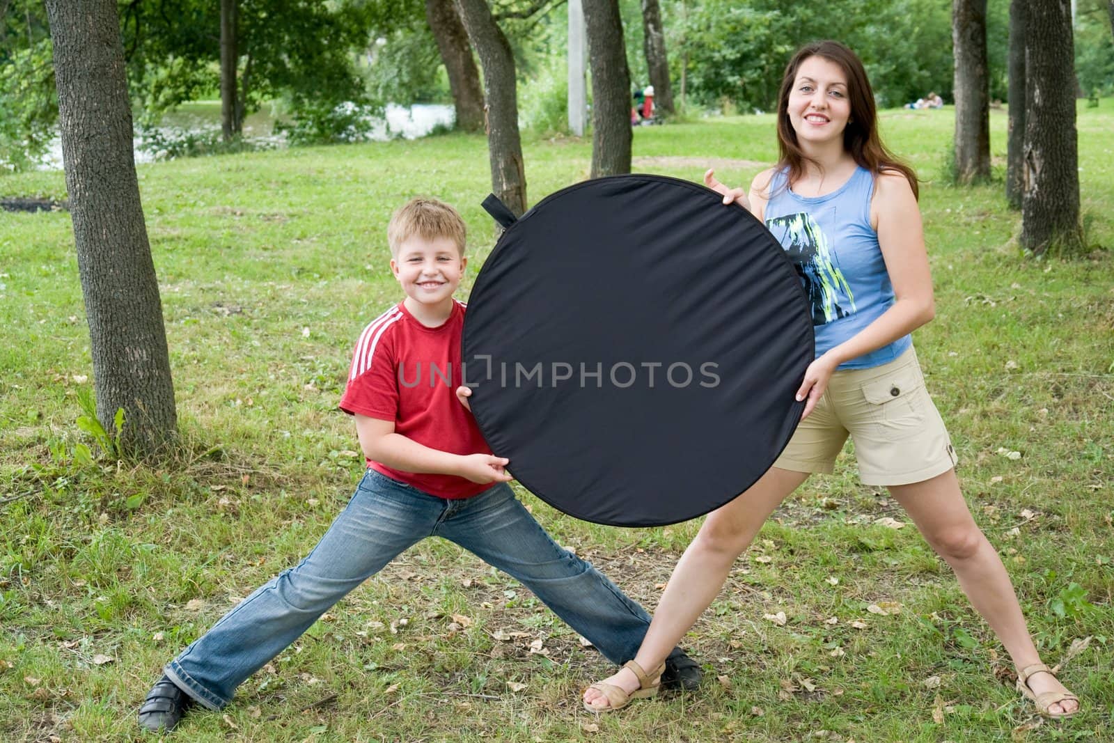 Mum and the son with black circle for an inscription in a summer park.