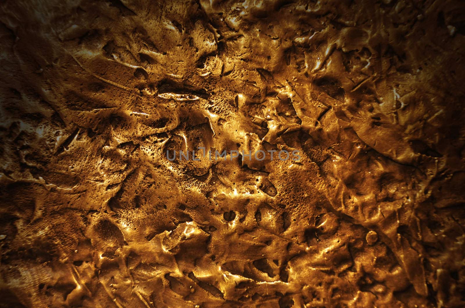 Close-up on a bronze surface texture lit dramatically from above