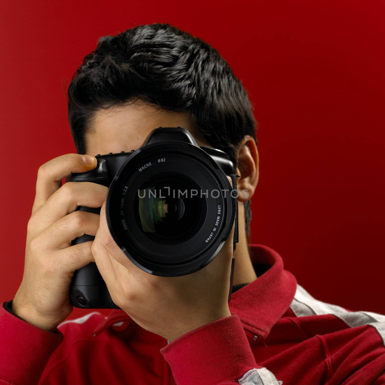 Photographer on red. Shallow DOF. Focus on Lens.