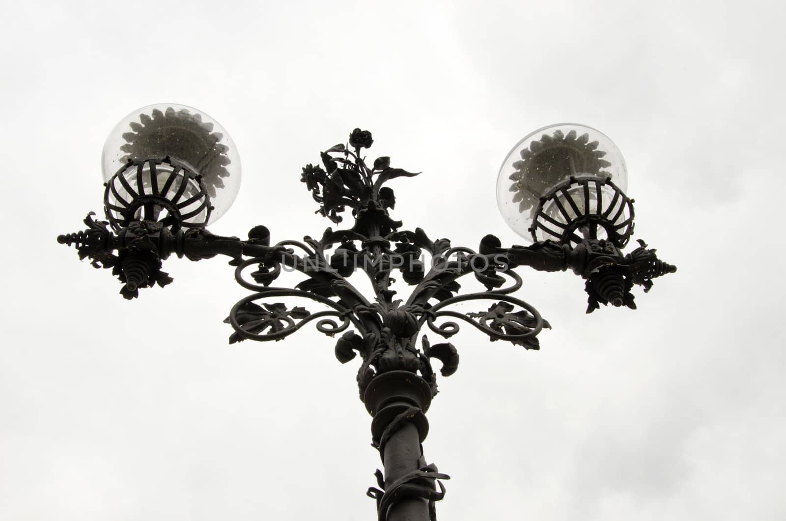 Lamp with metal stand and glass enclosure in park. by sauletas