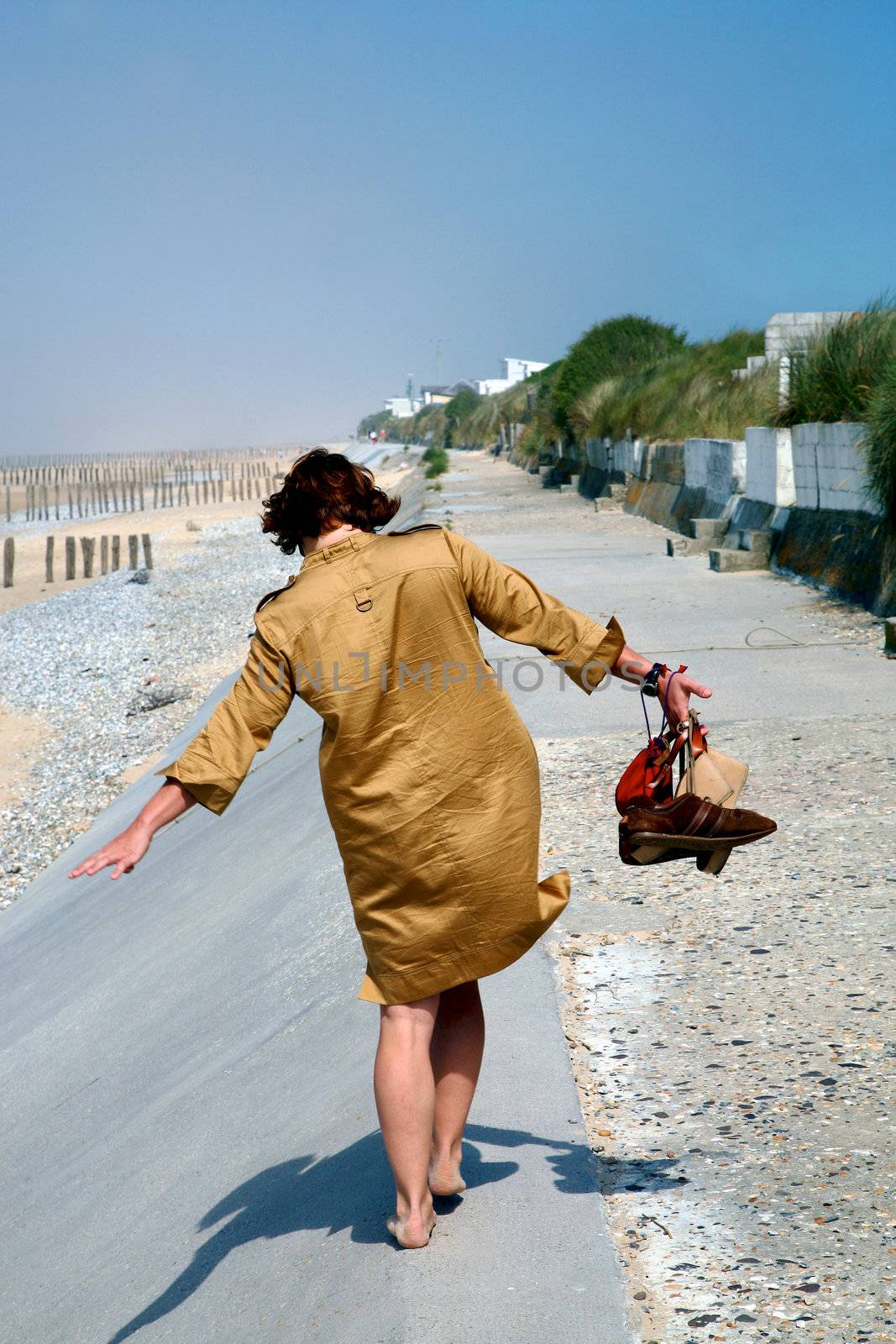 Woman walking on the beach with blue sky