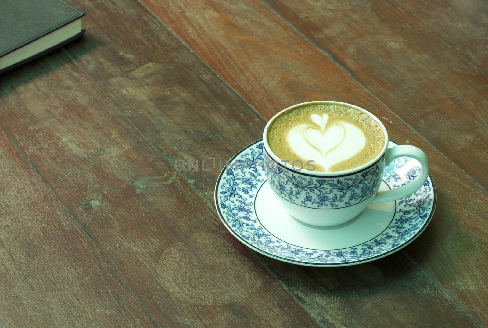 Cup of hot coffee and Notebook on wood table