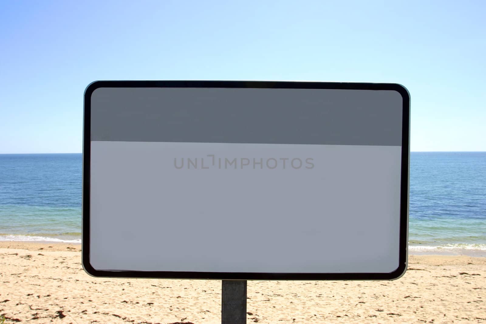 Blank beach sign on French beach with a blue sky