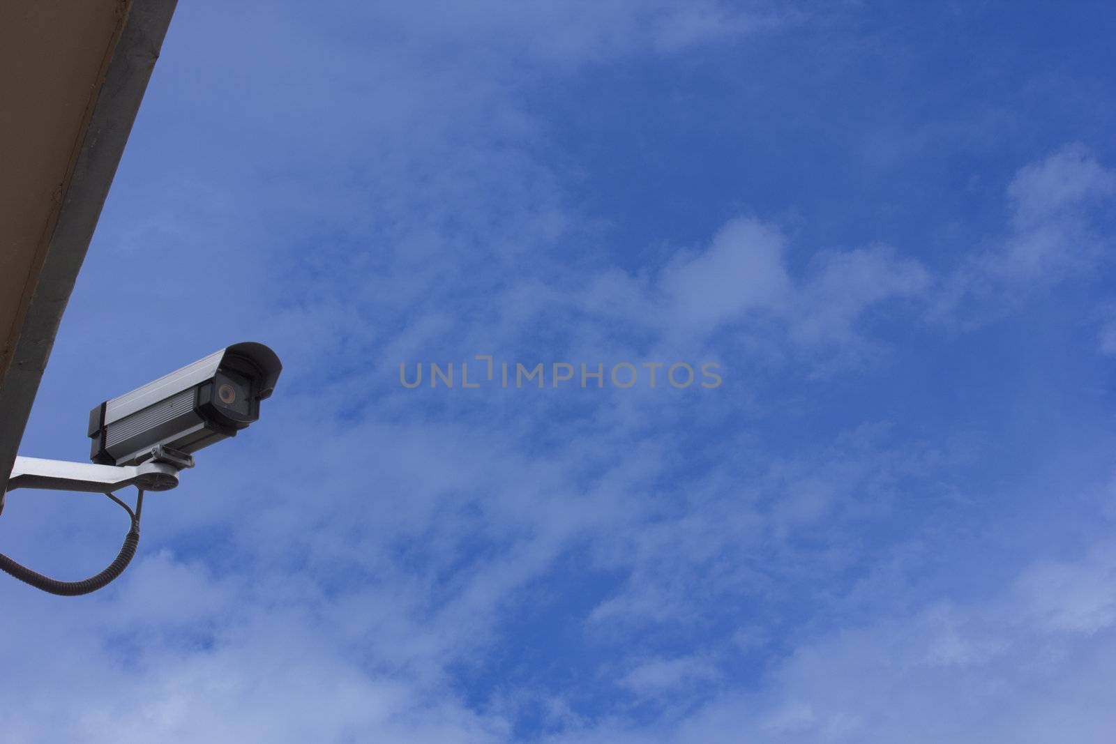 Security / surveillance camera against a clear blue sky