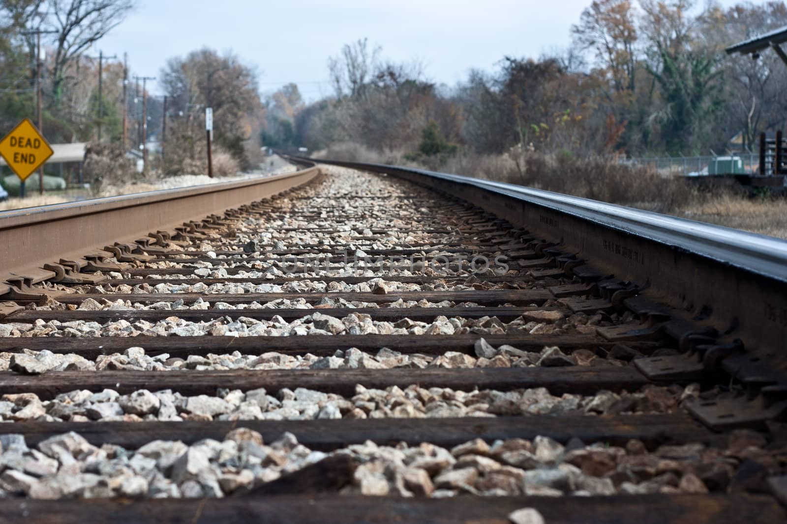 Train track leadin away with dead in sign.