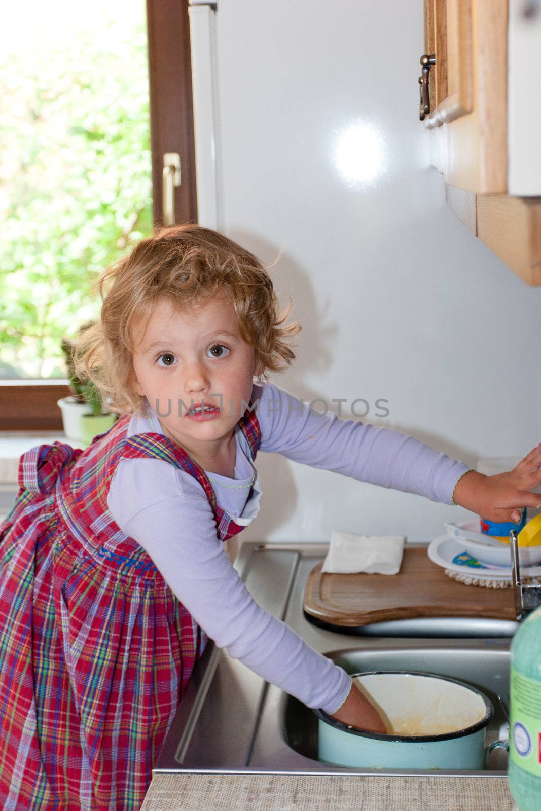 Little granddaughter helping grandma in a kitchen