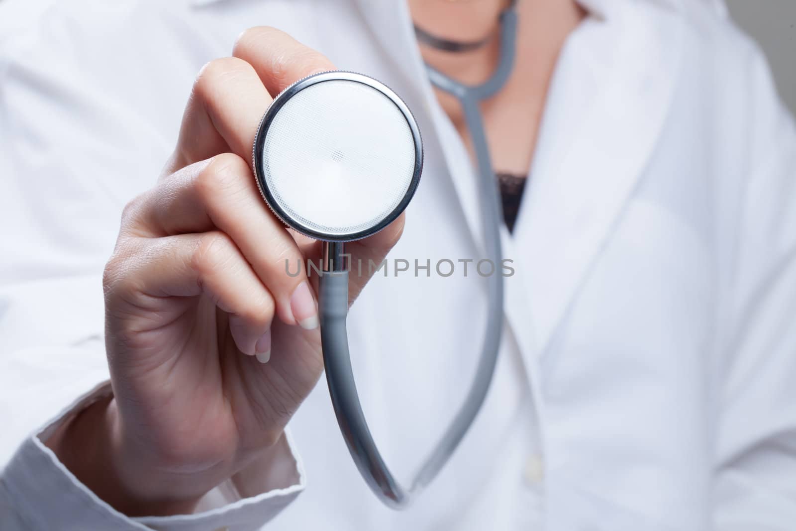 Female hand holding stethoscope; health care concept by Suriyaphoto