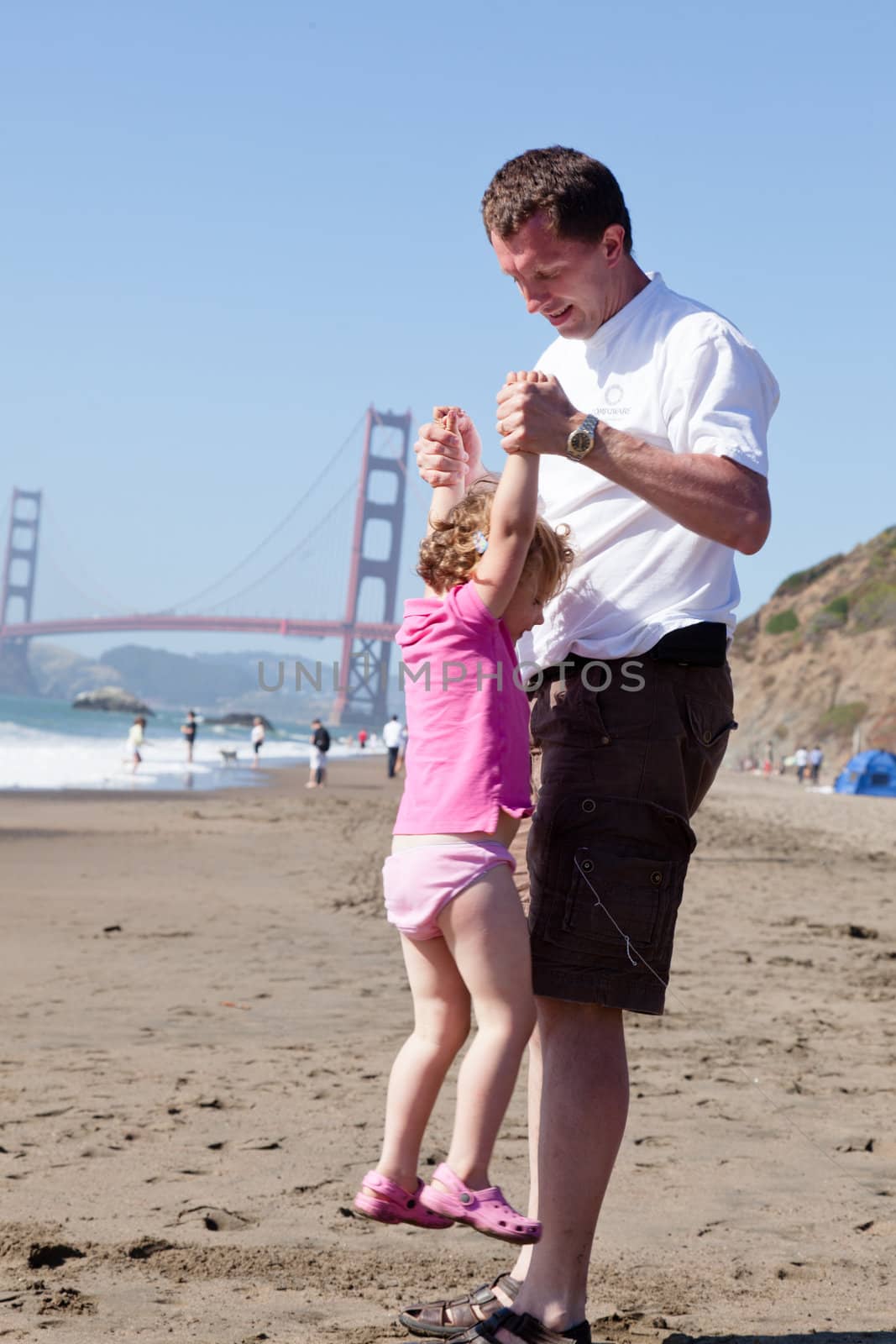 Father having fun with his daughter on the beach.