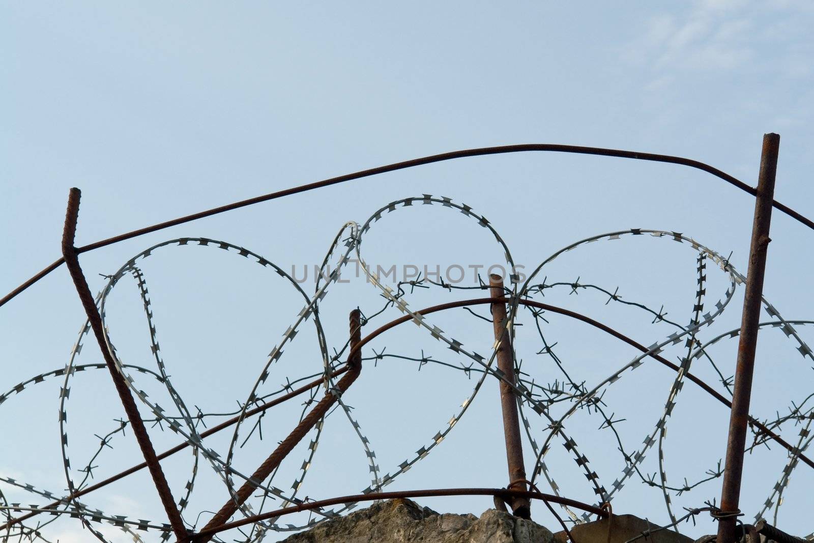 the barbed wire on a high fence 