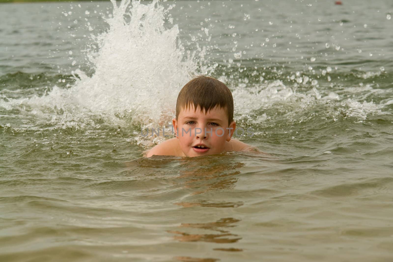 the little boy swims. splashes on a background