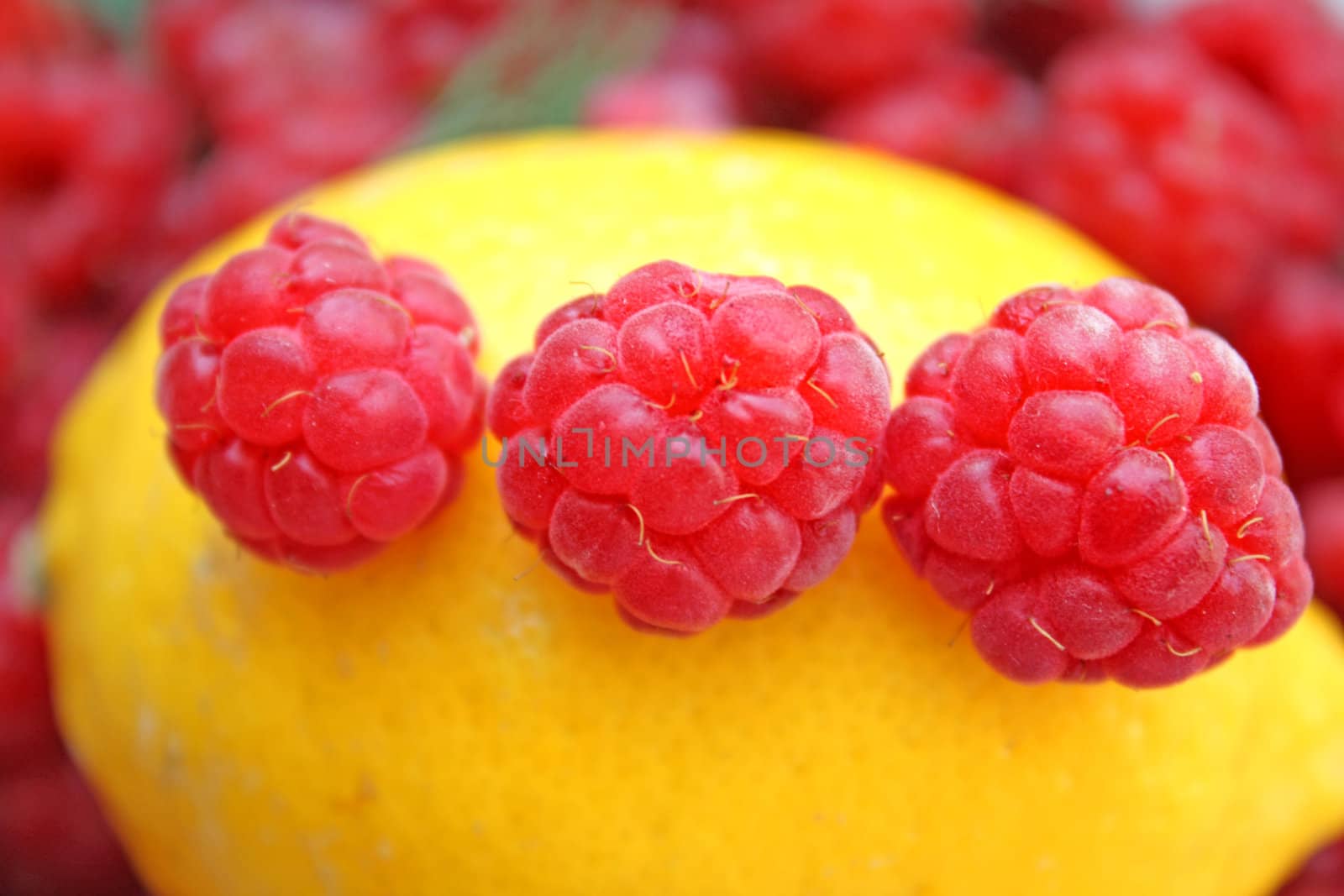 Close up of the three raspberries on the lemon