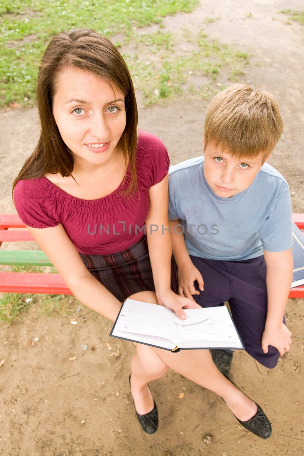 Mum and the son reads the book in park