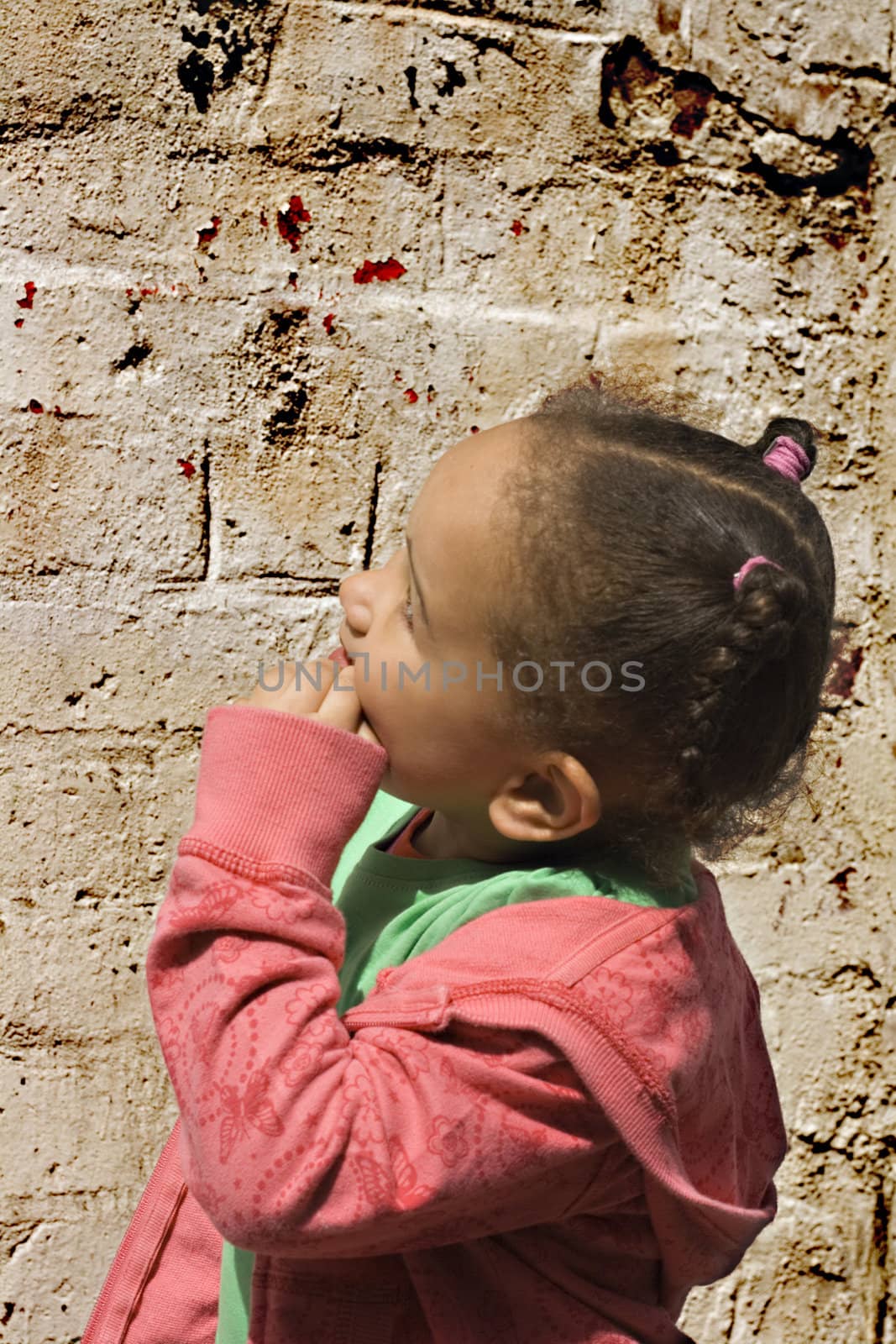 Young black baby girl playing in an alley