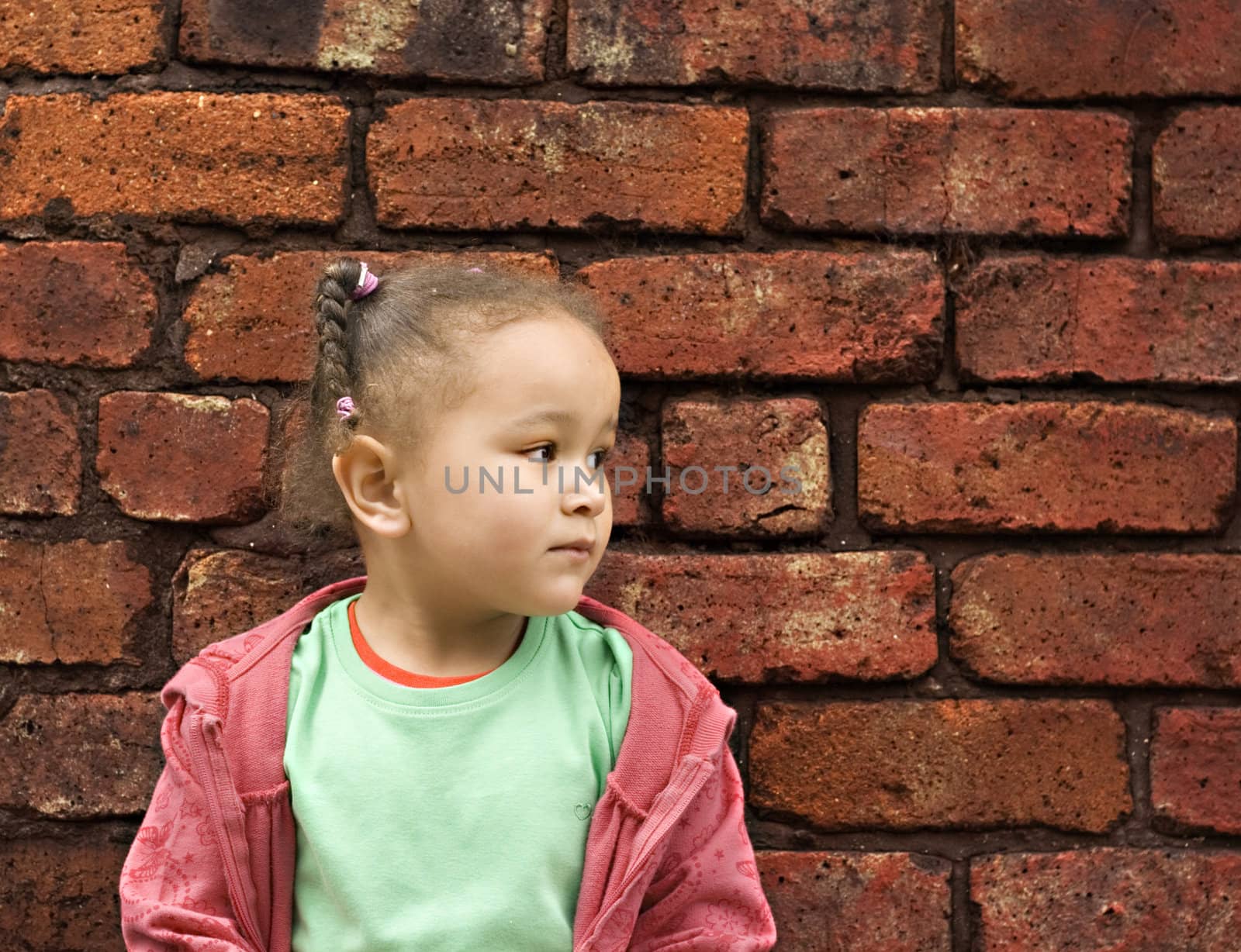 Young black baby girl playing in an alley