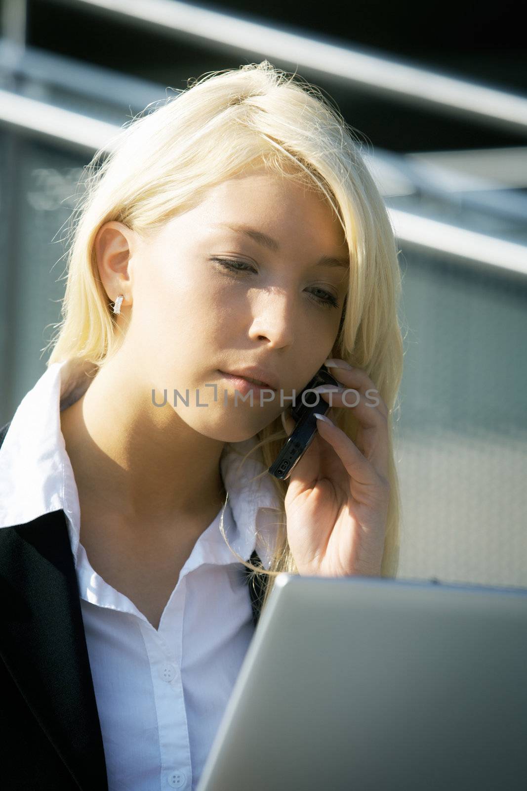 Young businesswoman using laptop computer in city, sitting on stairway