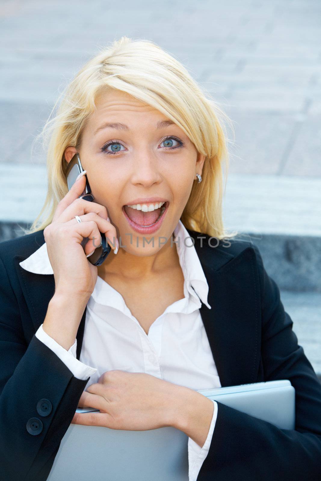 Young businesswoman sitting on stairway, using cell phone