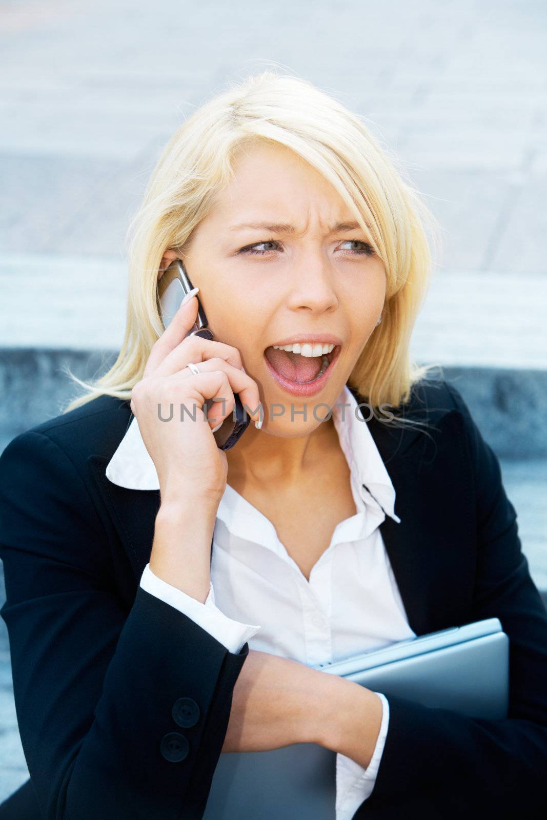 Young businesswoman sitting on stairway, using cell phone