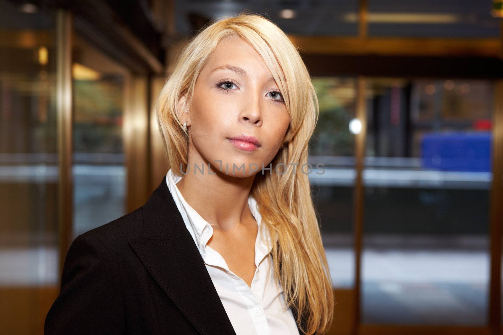 Young businesswoman looking at camera, frontal portrait