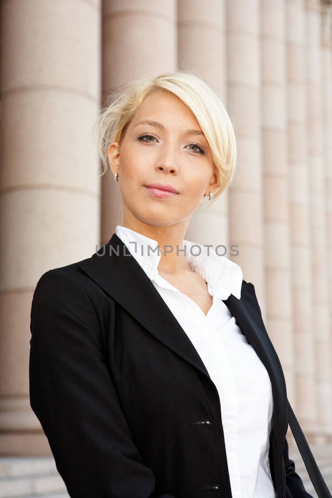 Portrait of young businesswoman outside building, looking at camera