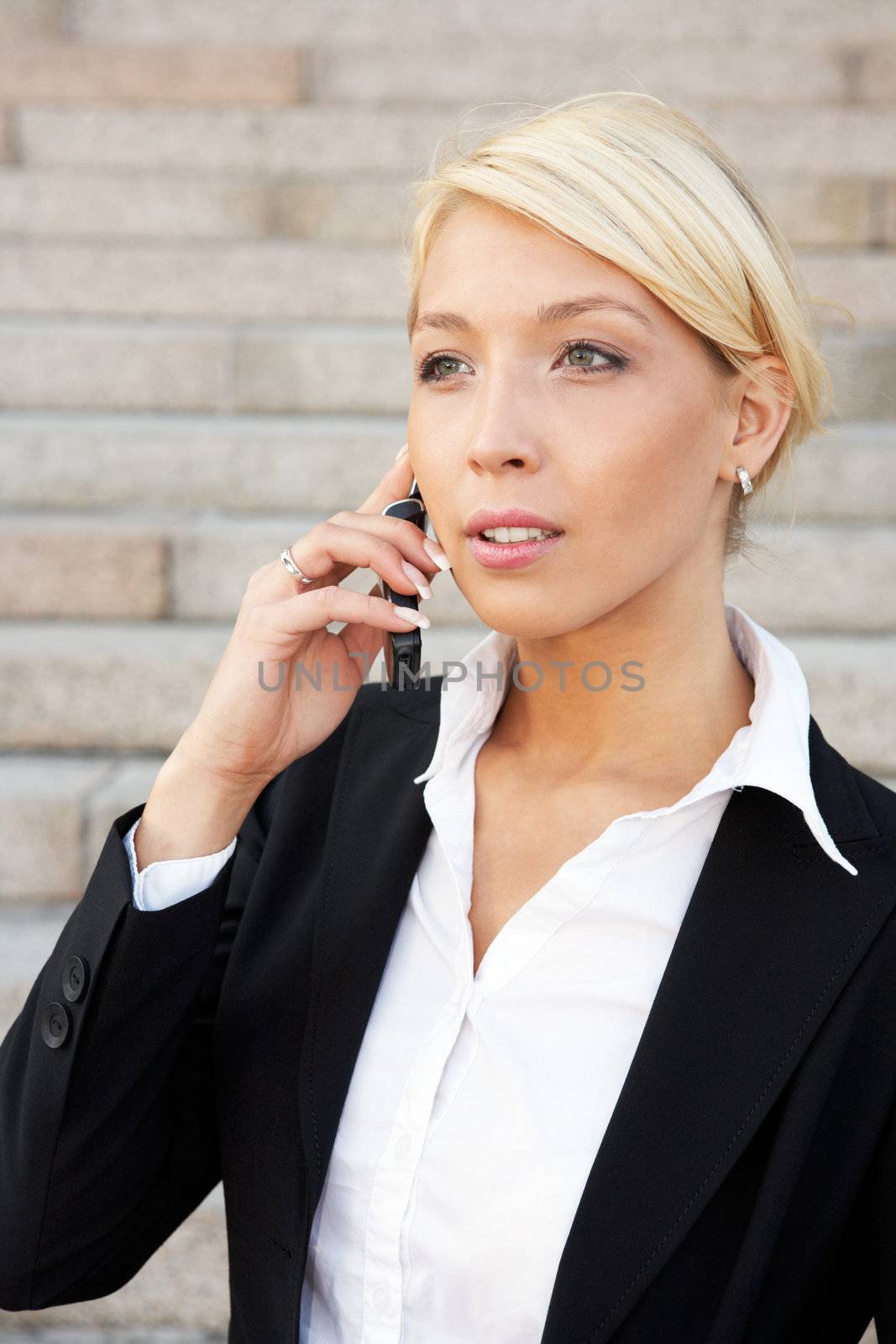 Young businesswoman using mobile phone outside building