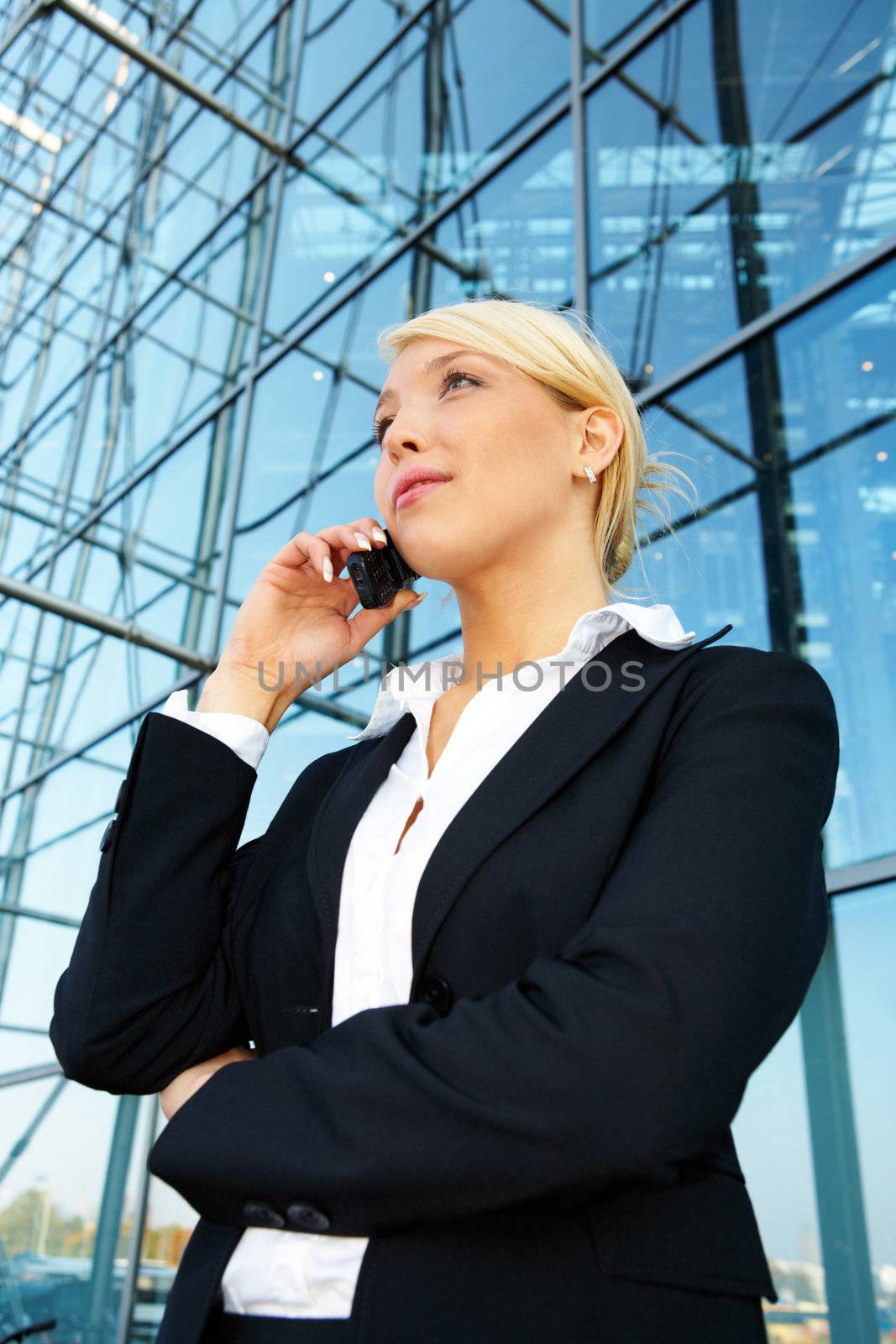 Young businesswoman using mobile phone, looking up