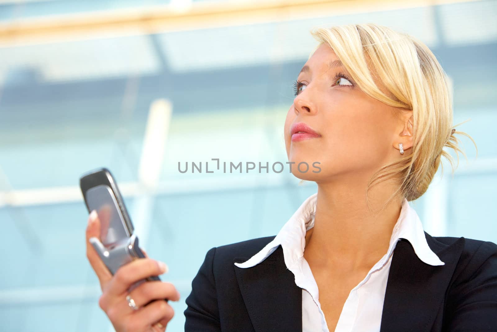 Businesswoman holding mobile phone, contemplating