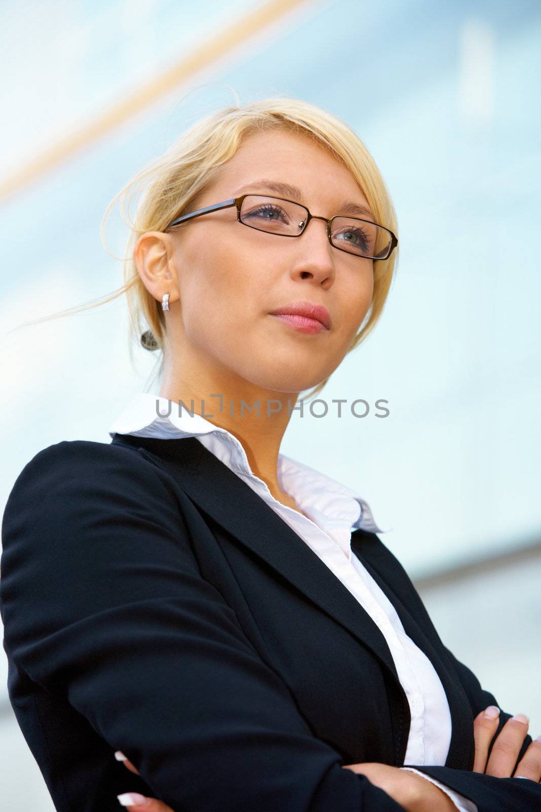 Young businesswoman contemplating outside office building