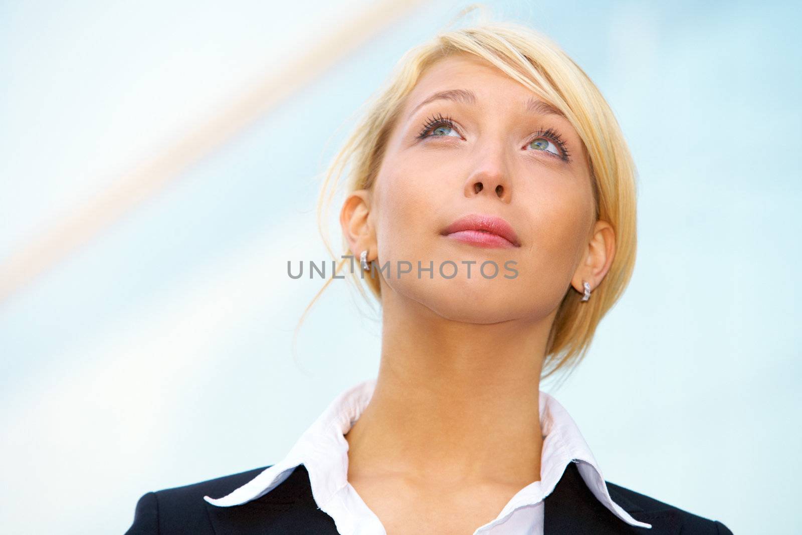 Young businesswoman looking up outside office building