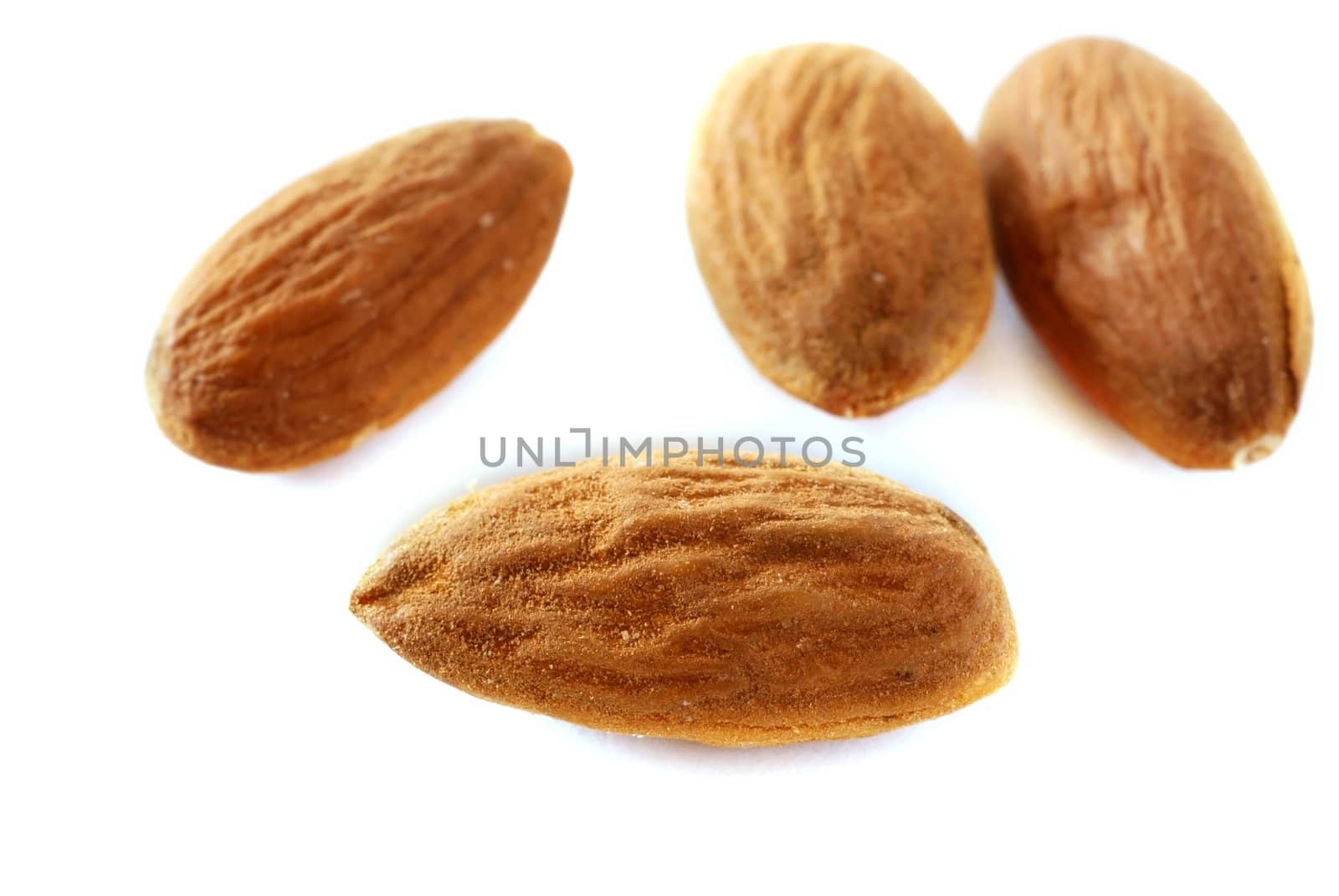 brown raw almonds over white background macro