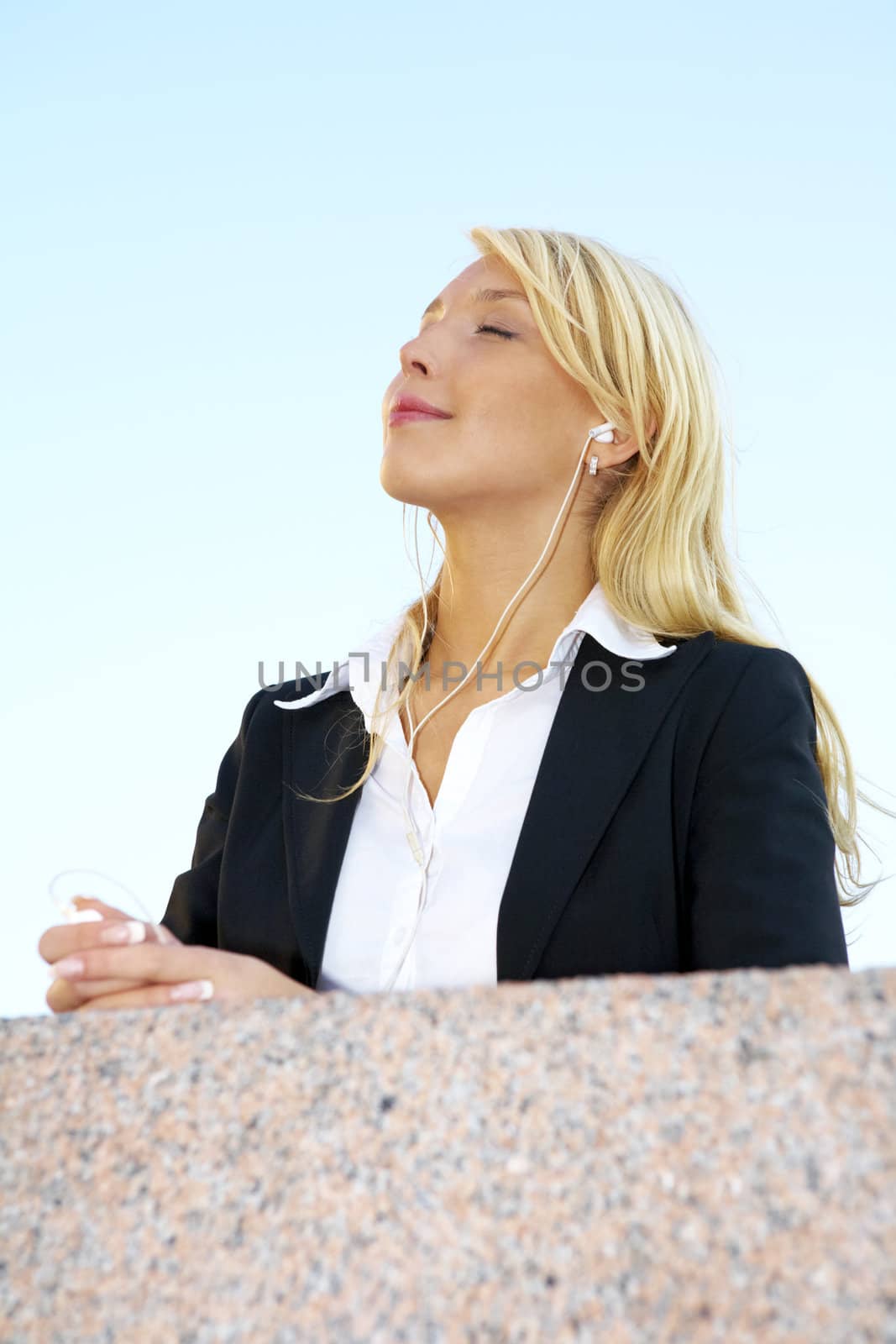 Young businesswoman listening to audio player eyes closed