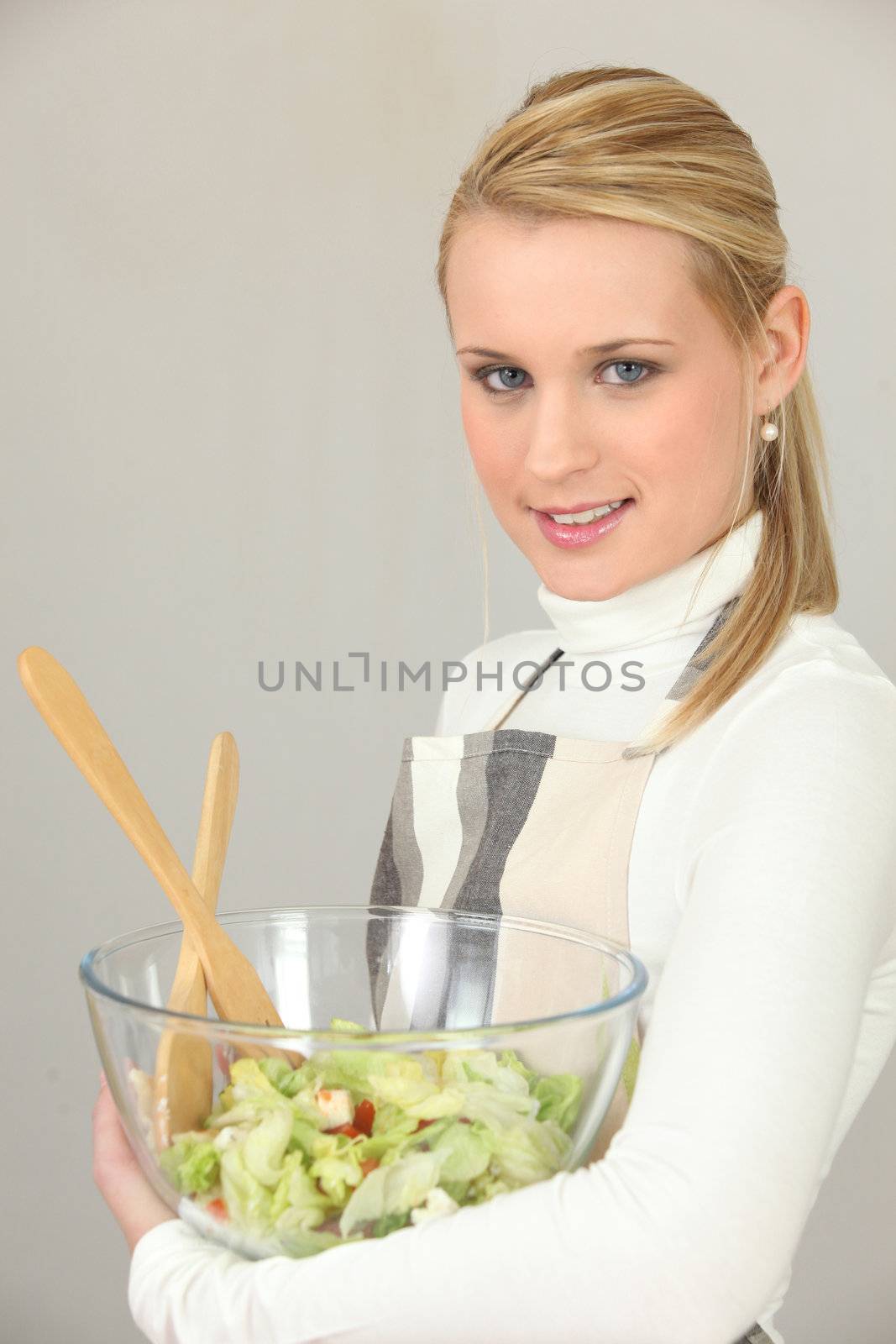 Woman carrying bowl of salad on white background by phovoir
