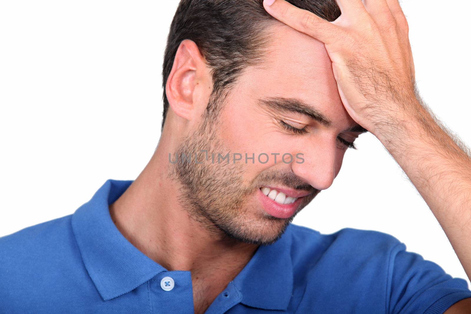 a 35 years old man taking his head with his hand, his face expresses failure