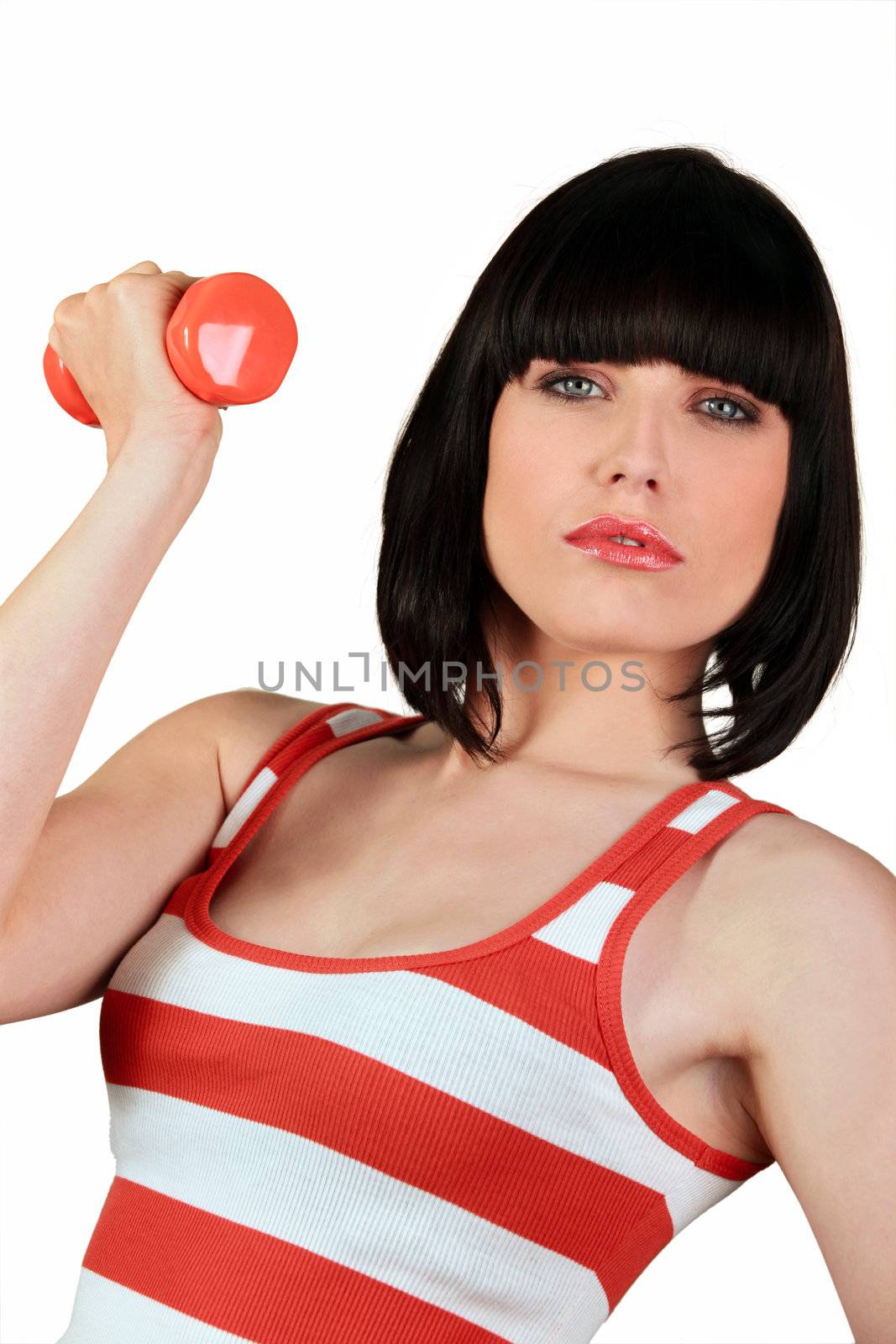 Attractive brunette lifting weights in gym