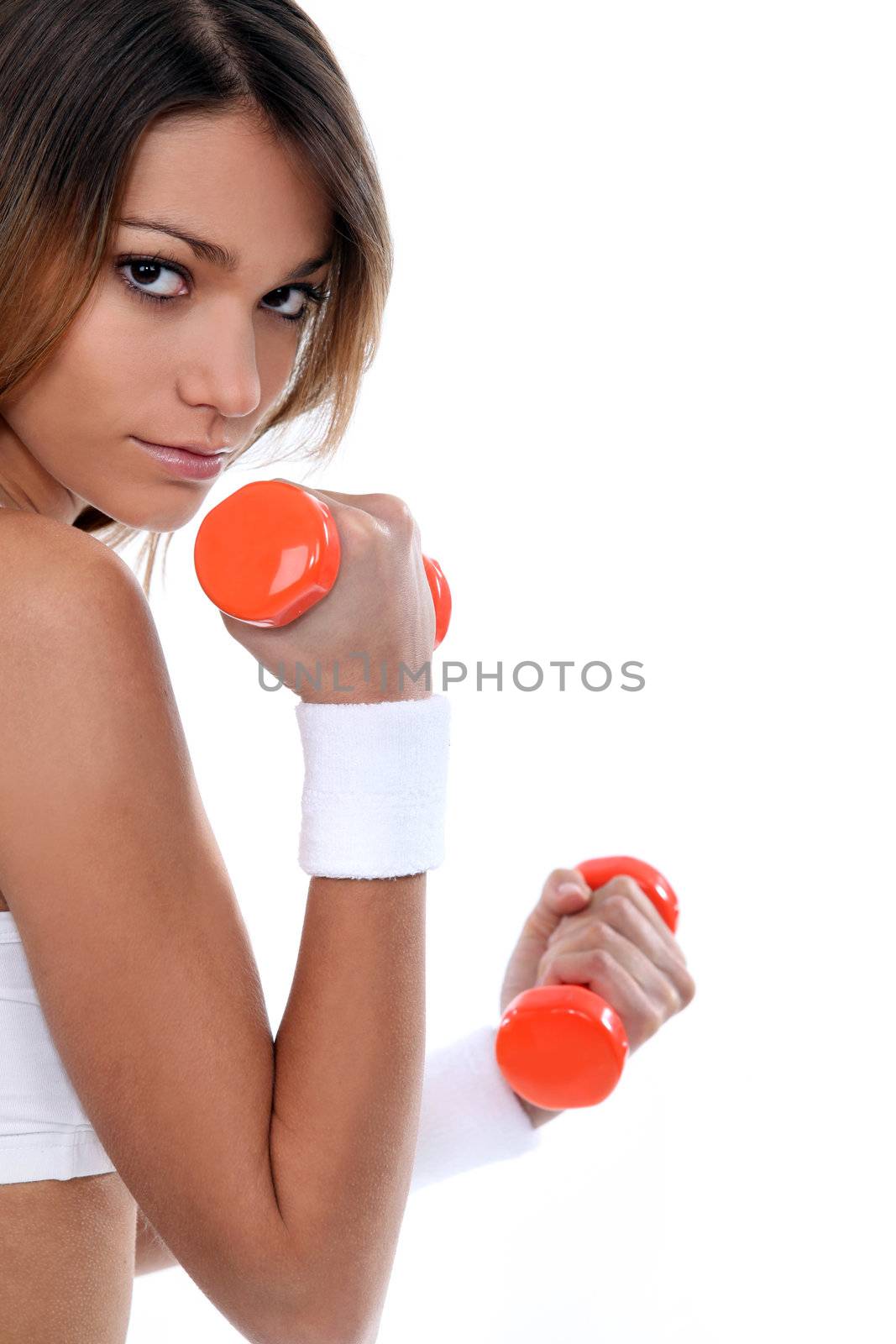 Young woman lifting weights by phovoir
