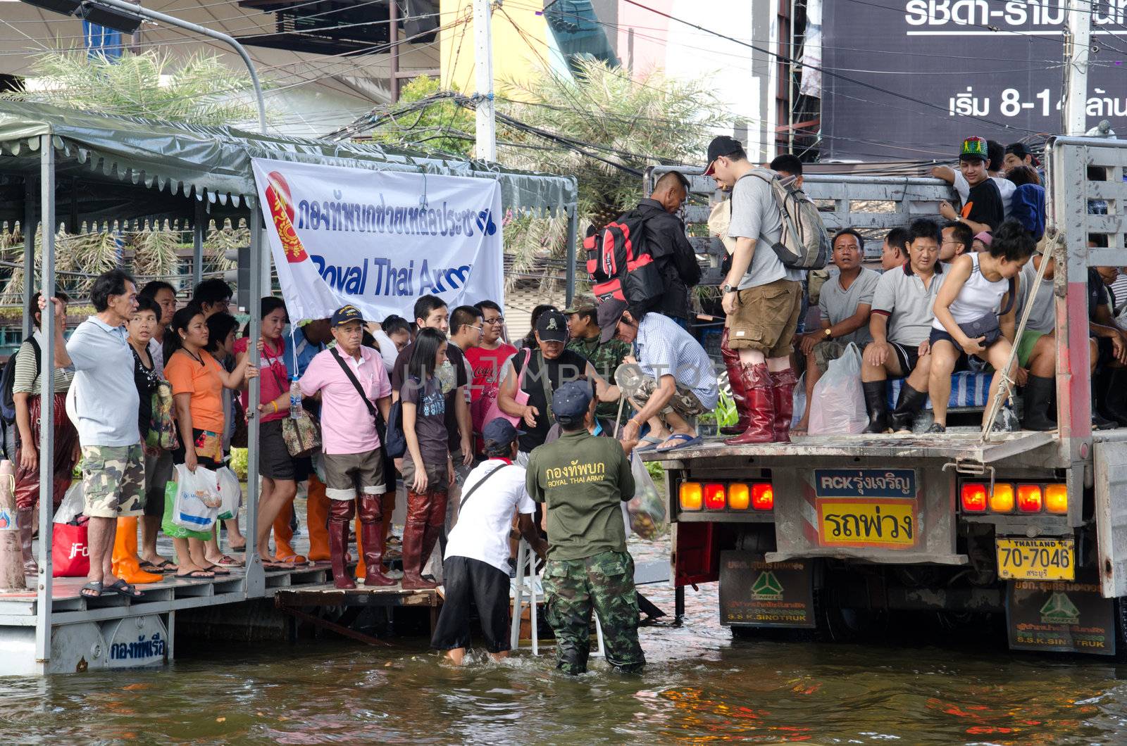 BANGKOK THAILAND – NOVEMBER 13: Truck carries a group of people to evacuate from the flooded area at Phahon Yothin Road during the massive flood crisis on November 13, 2011 in Bangkok, Thailand.