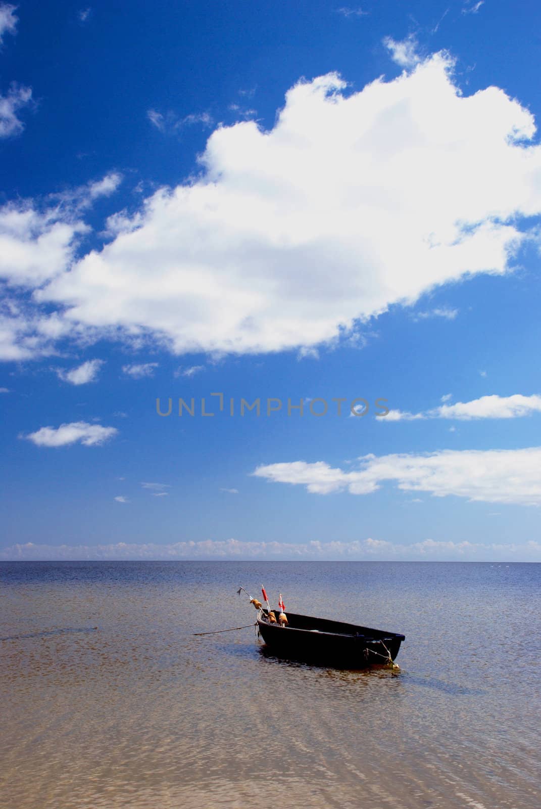 Plastic boat with floats tied at the seaside. Nice view of lake and sky.