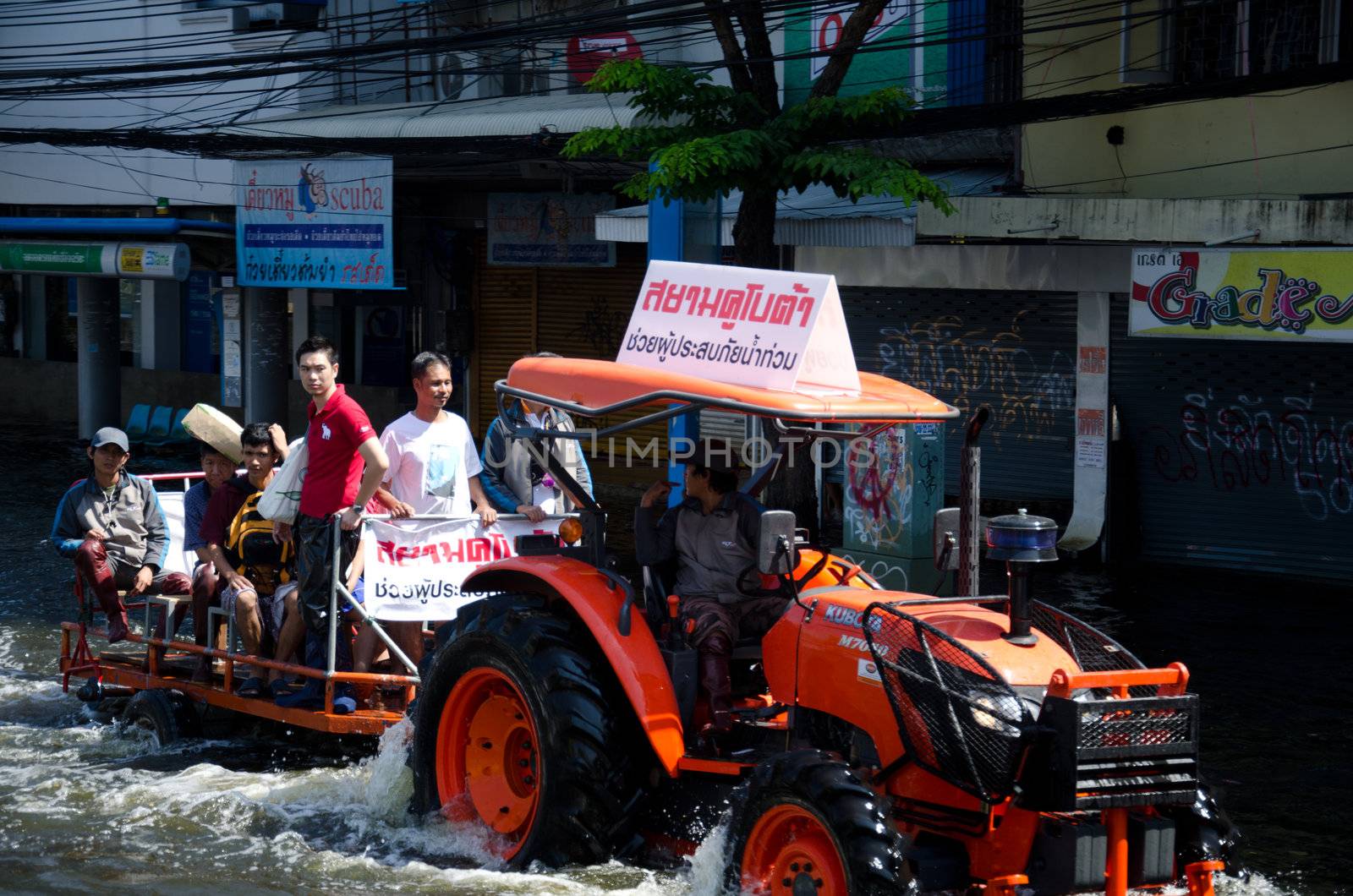 BANGKOK THAILAND – NOVEMBER 13: Truck carries a group of people to evacuate from the flooded area at Phahon Yothin Road during the massive flood crisis on November 13, 2011 in Bangkok, Thailand.