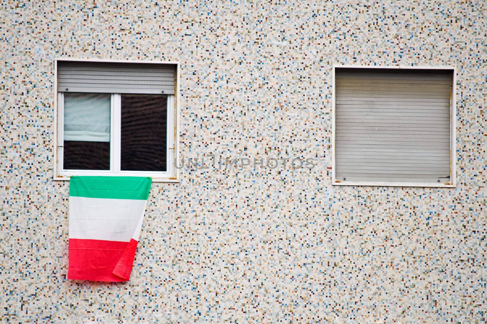 Italian flag on window with balcony in foreground