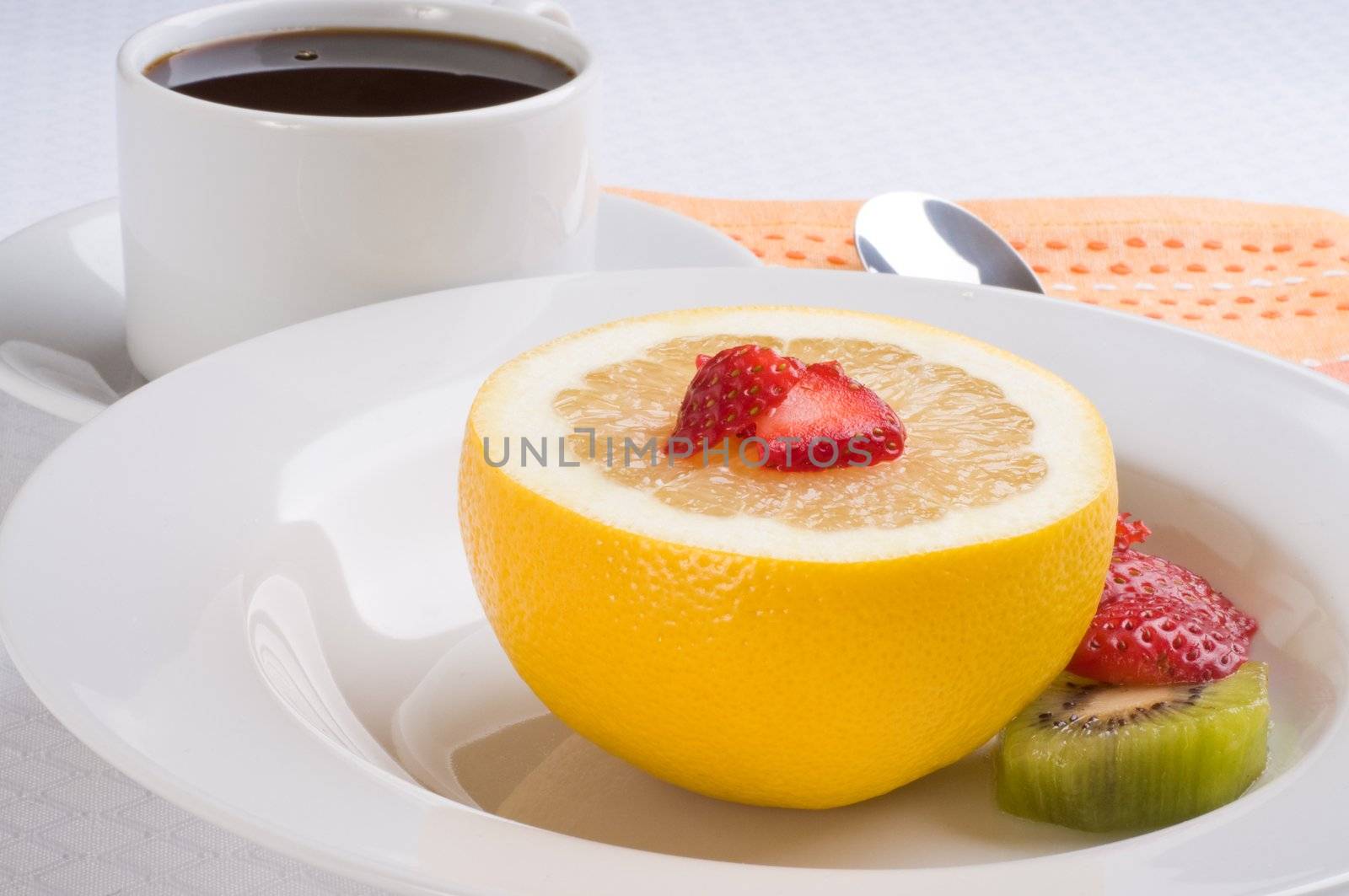 Healthy breakfast of fresh grapefruit, strawberries and kiwi.