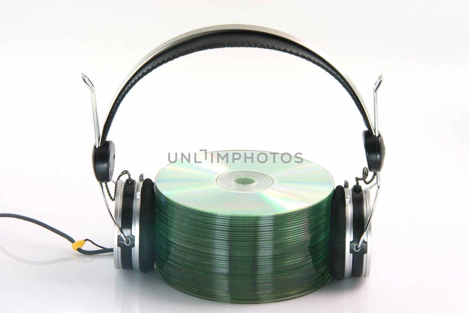 headphones and pile of compact discs isolated on white background