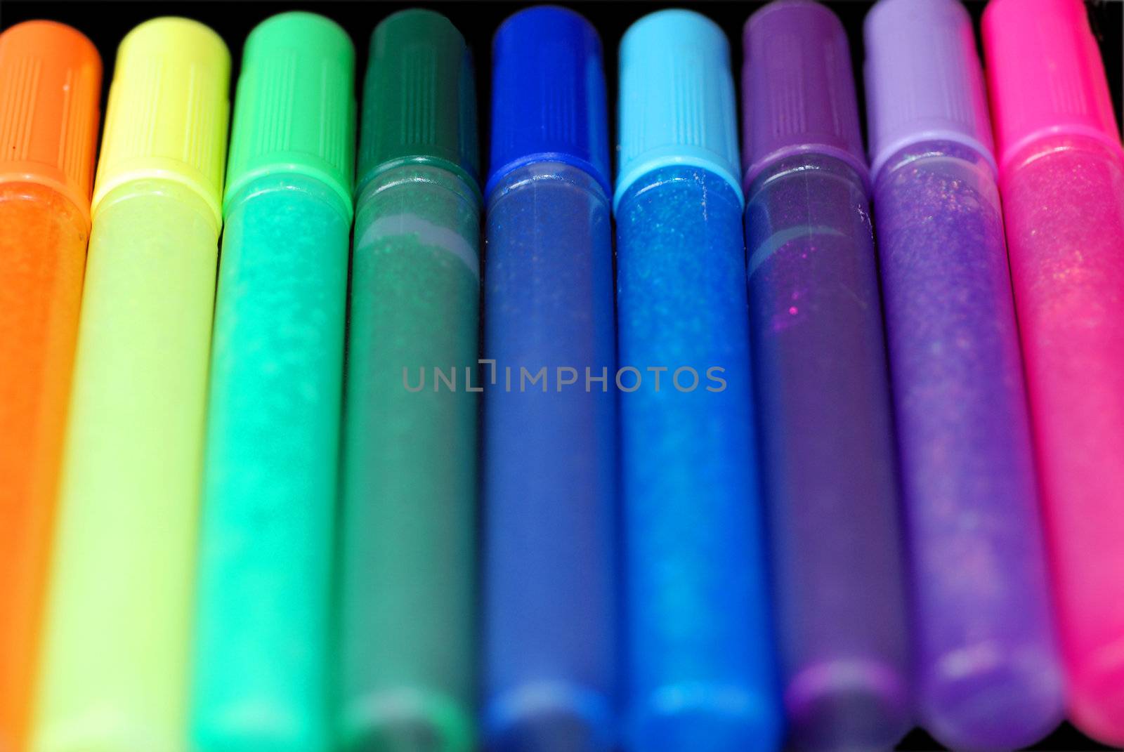 A row of brightly coloured glitter glue pens