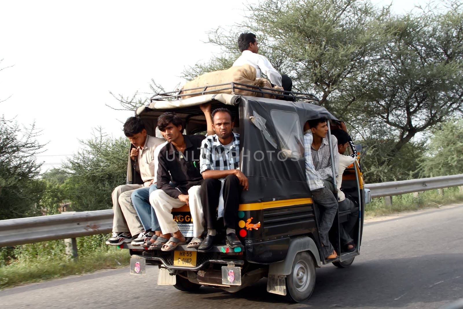 crazy road scene in India - small car with people