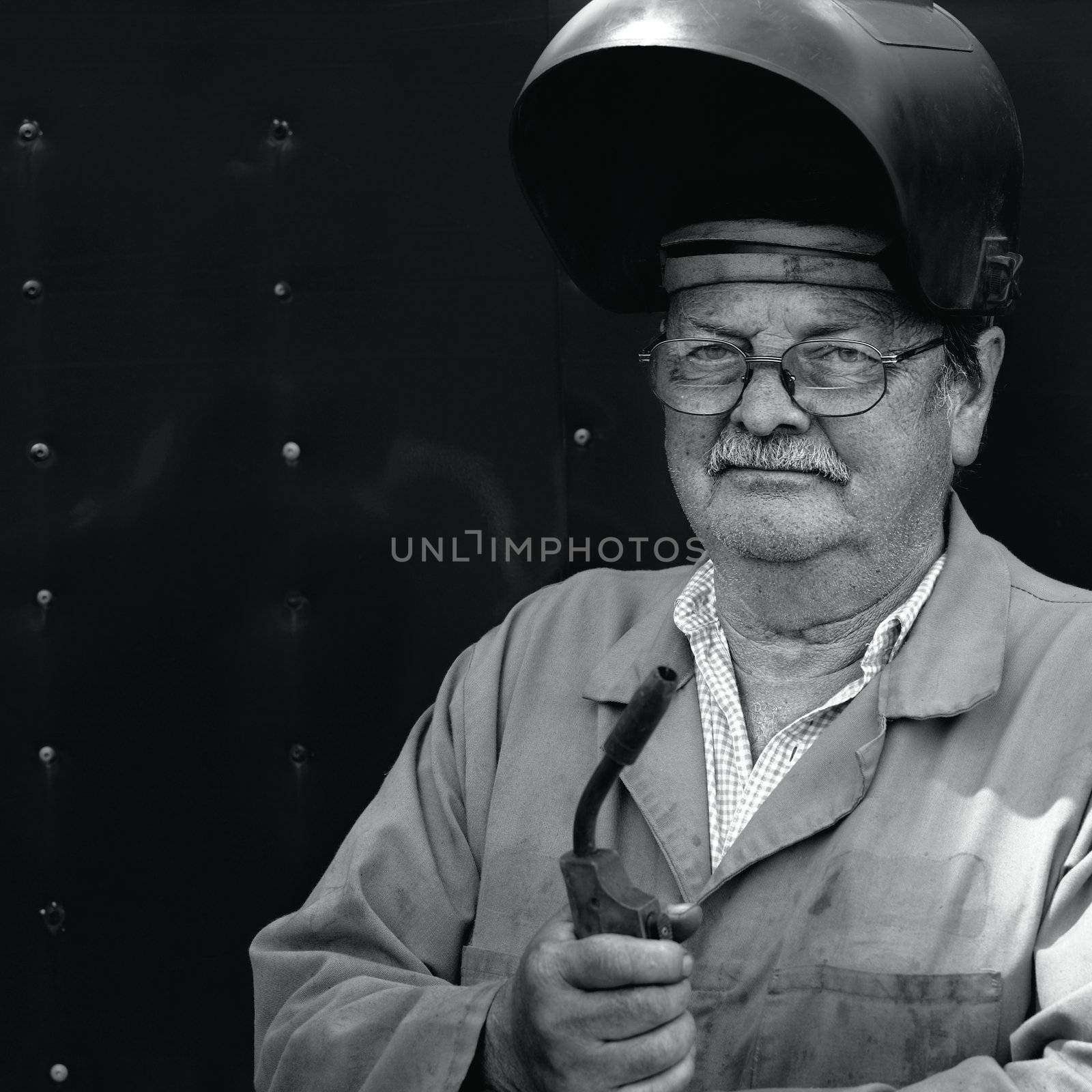 A senior in his 60's taking a break from his job as a welder.
