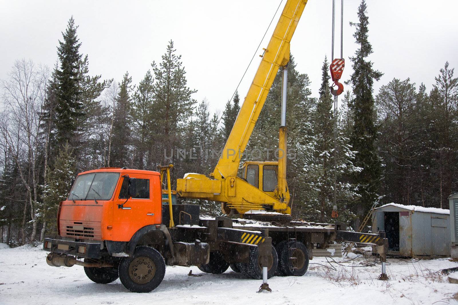 crane working in the woods in winter by AleksandrN