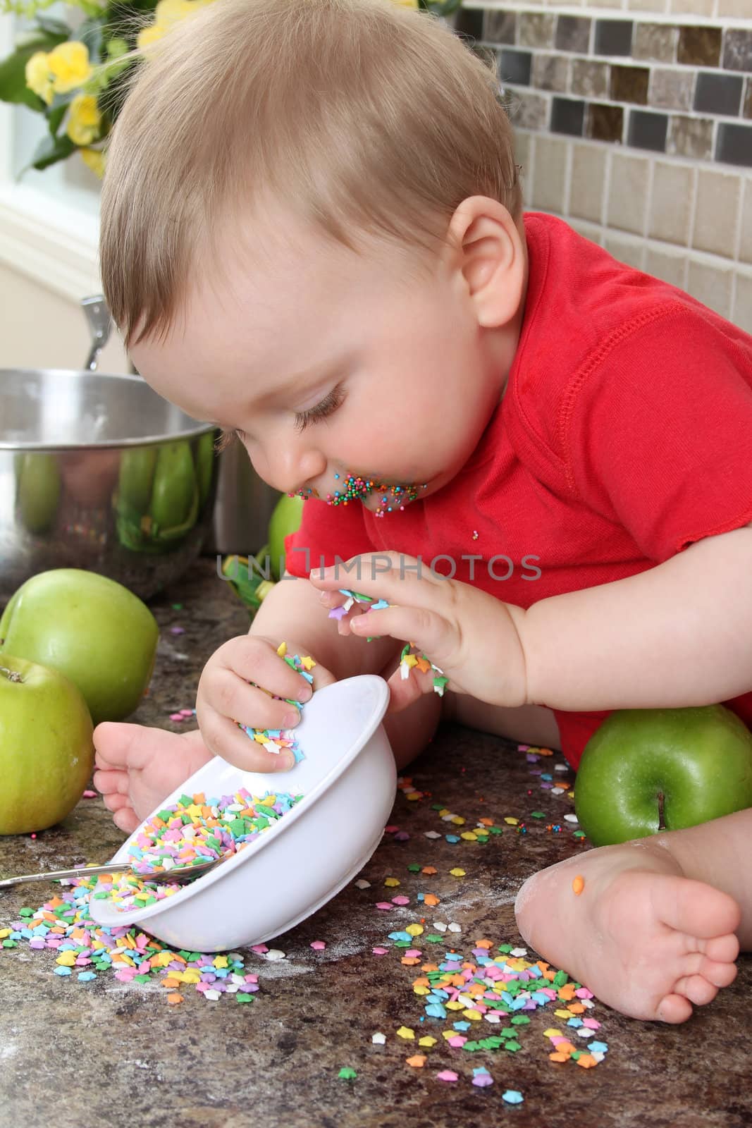 Baby boy playing on messy counter top