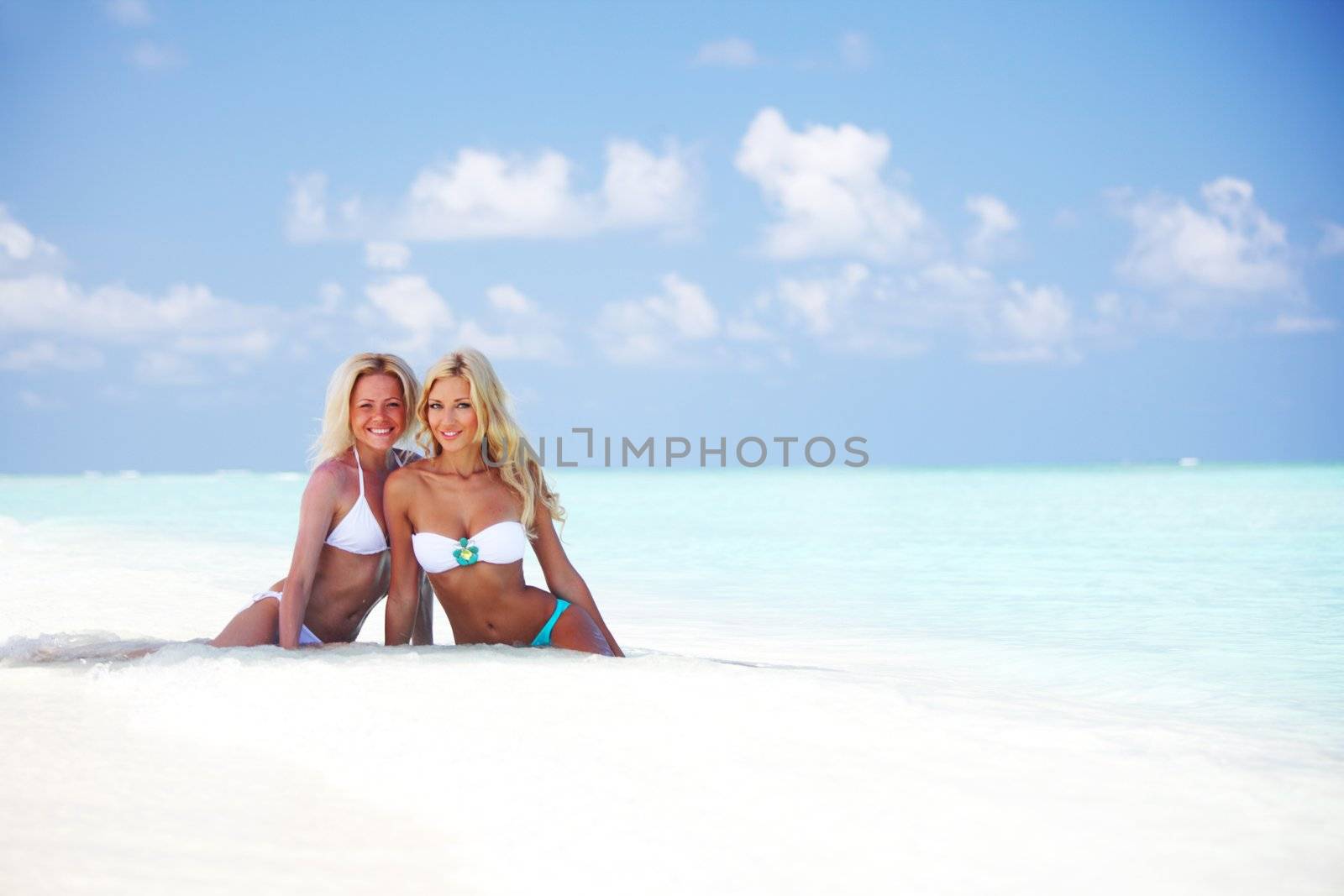 girls sitting on ocean coast by Yellowj