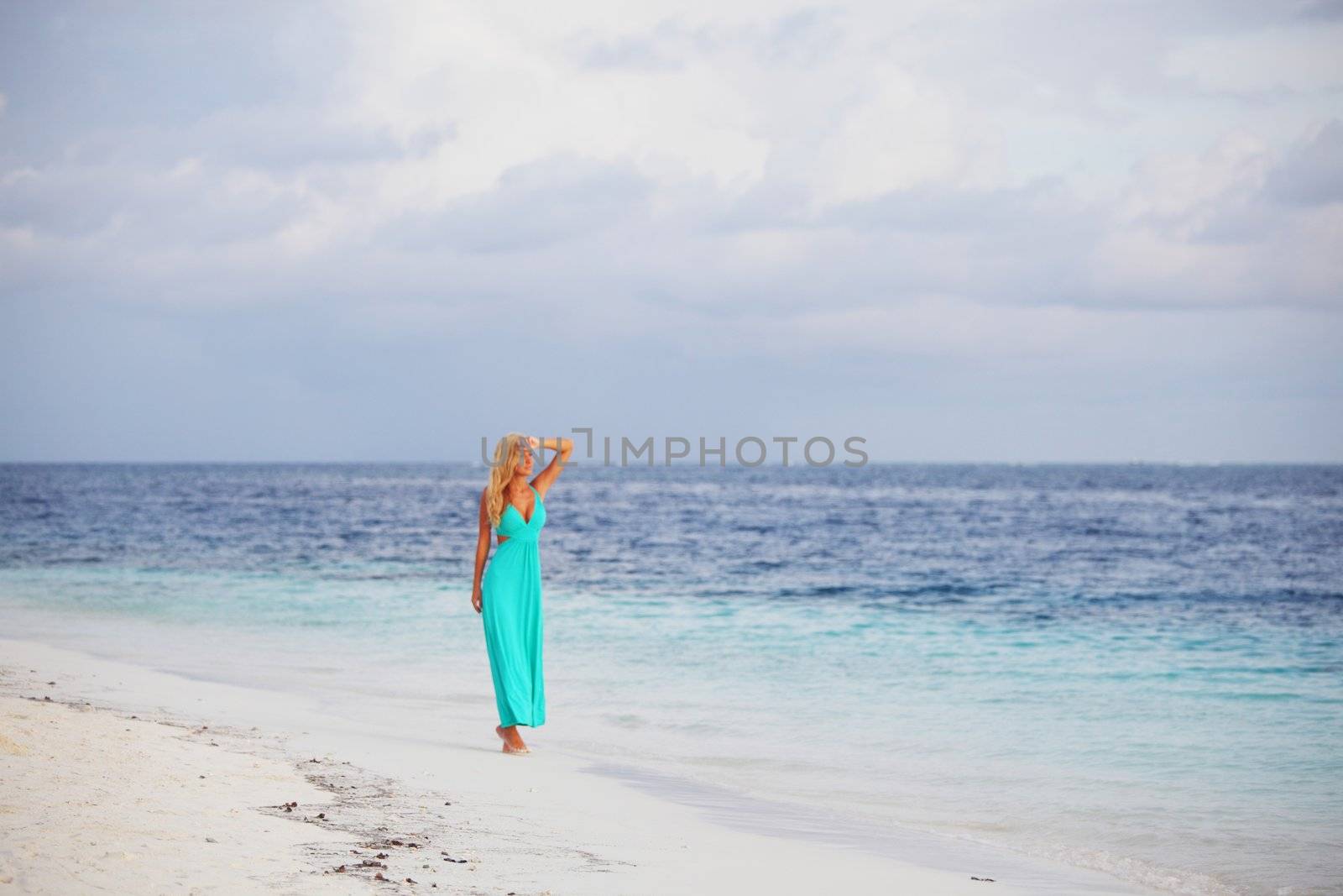 woman in a blue dress on the ocean coast